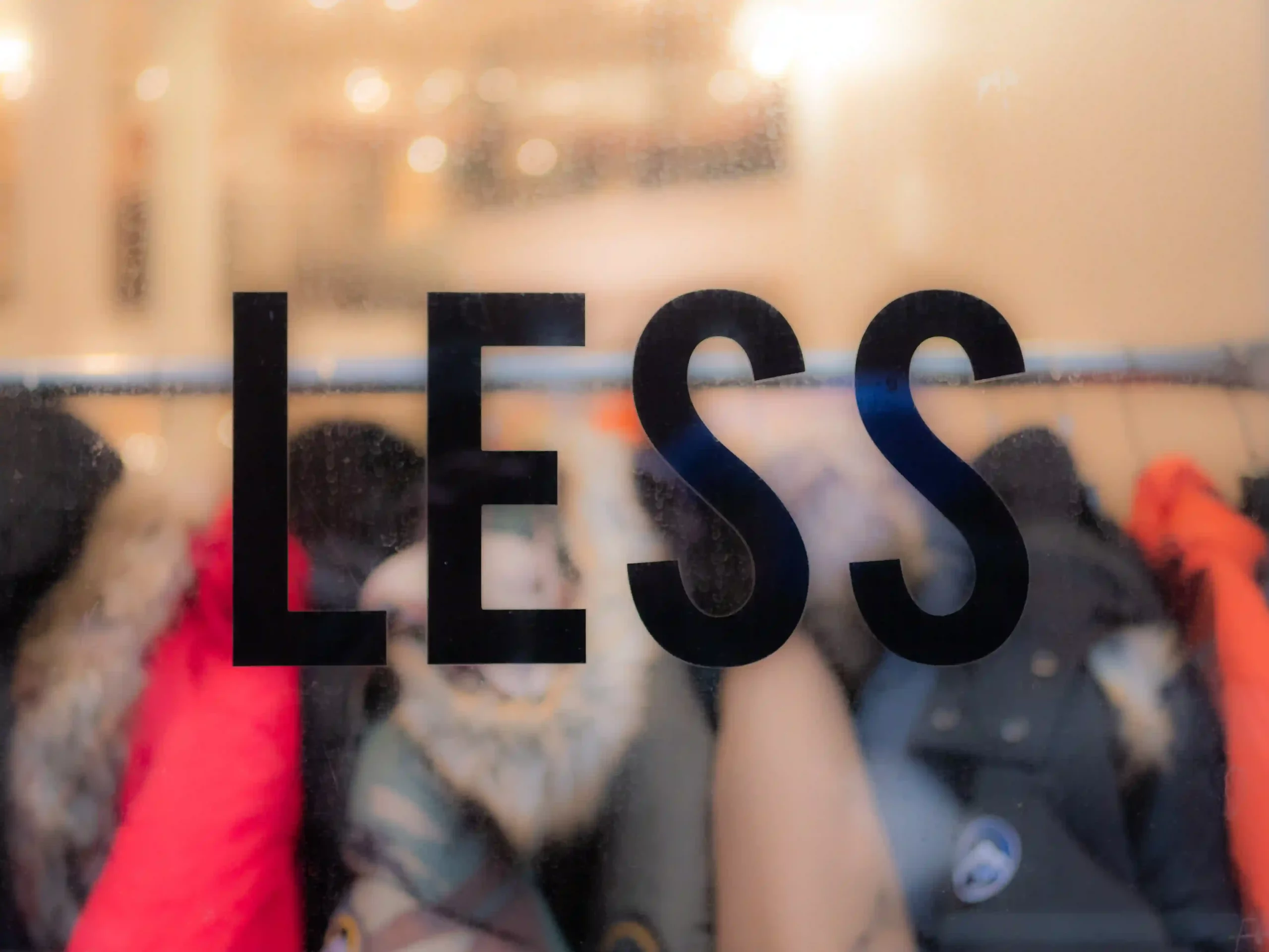 fashion shop window with "less" in black lettering