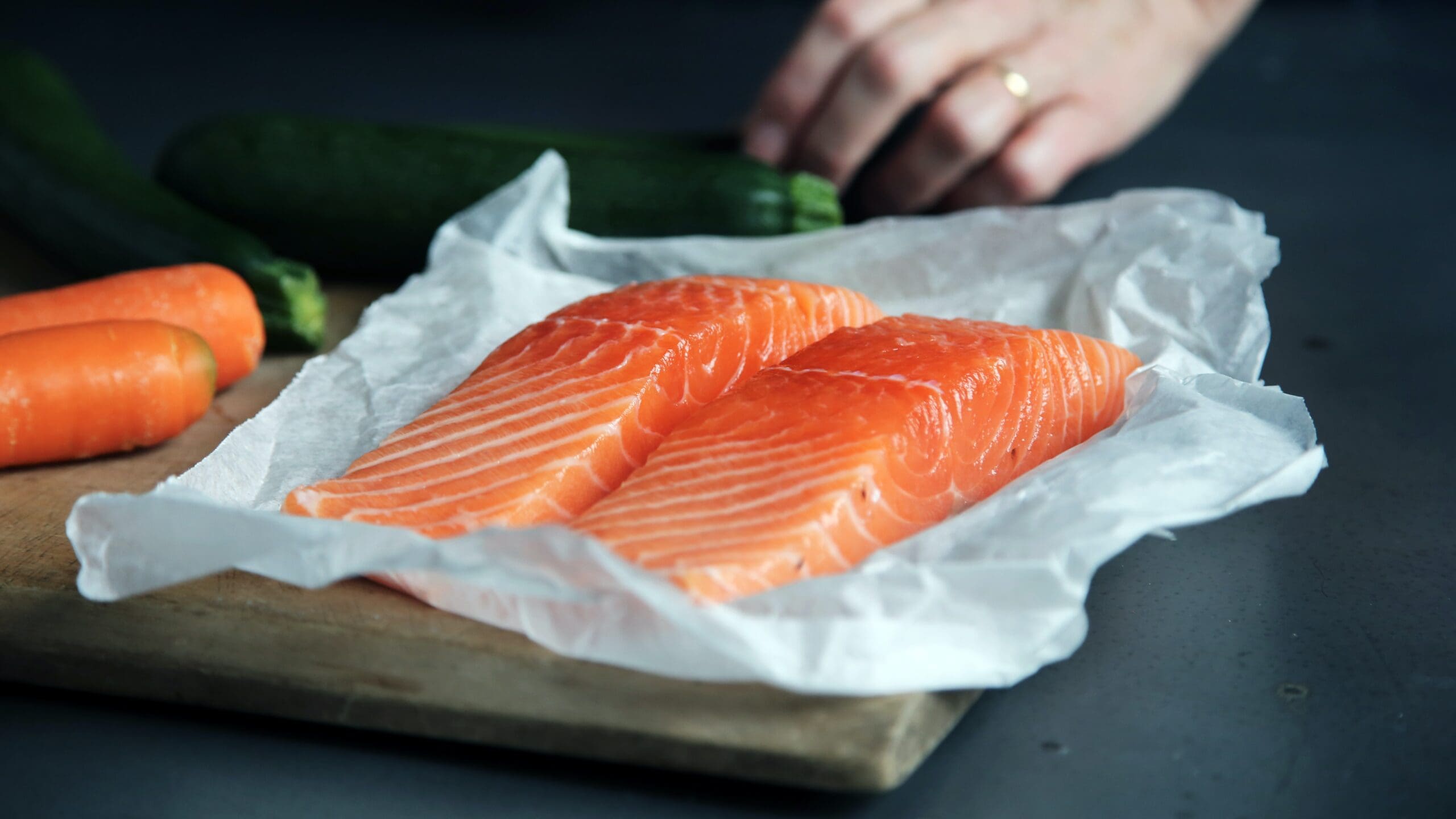 Two fillets of raw salmon on baking paper