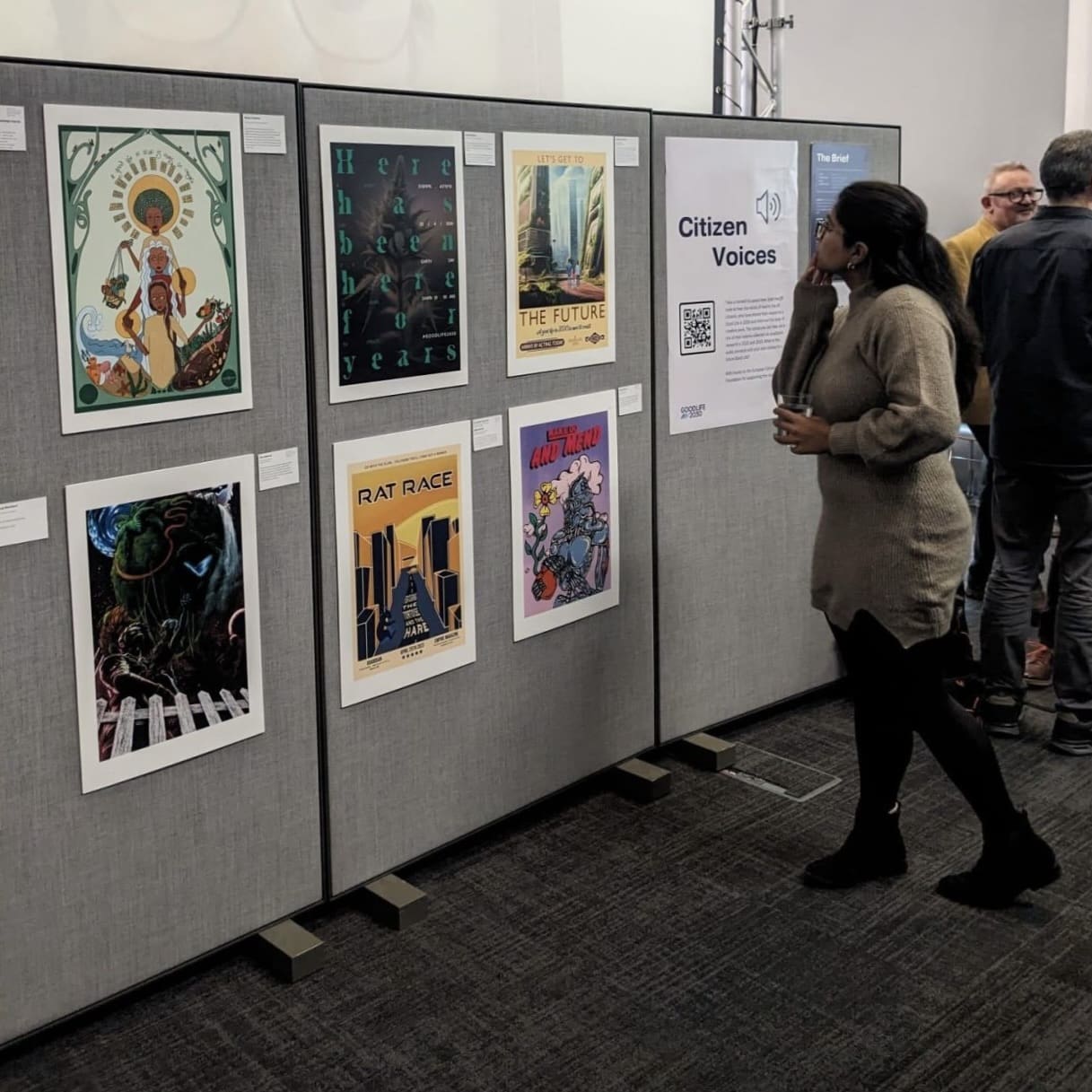 Women looking at a range of posters of a wall.