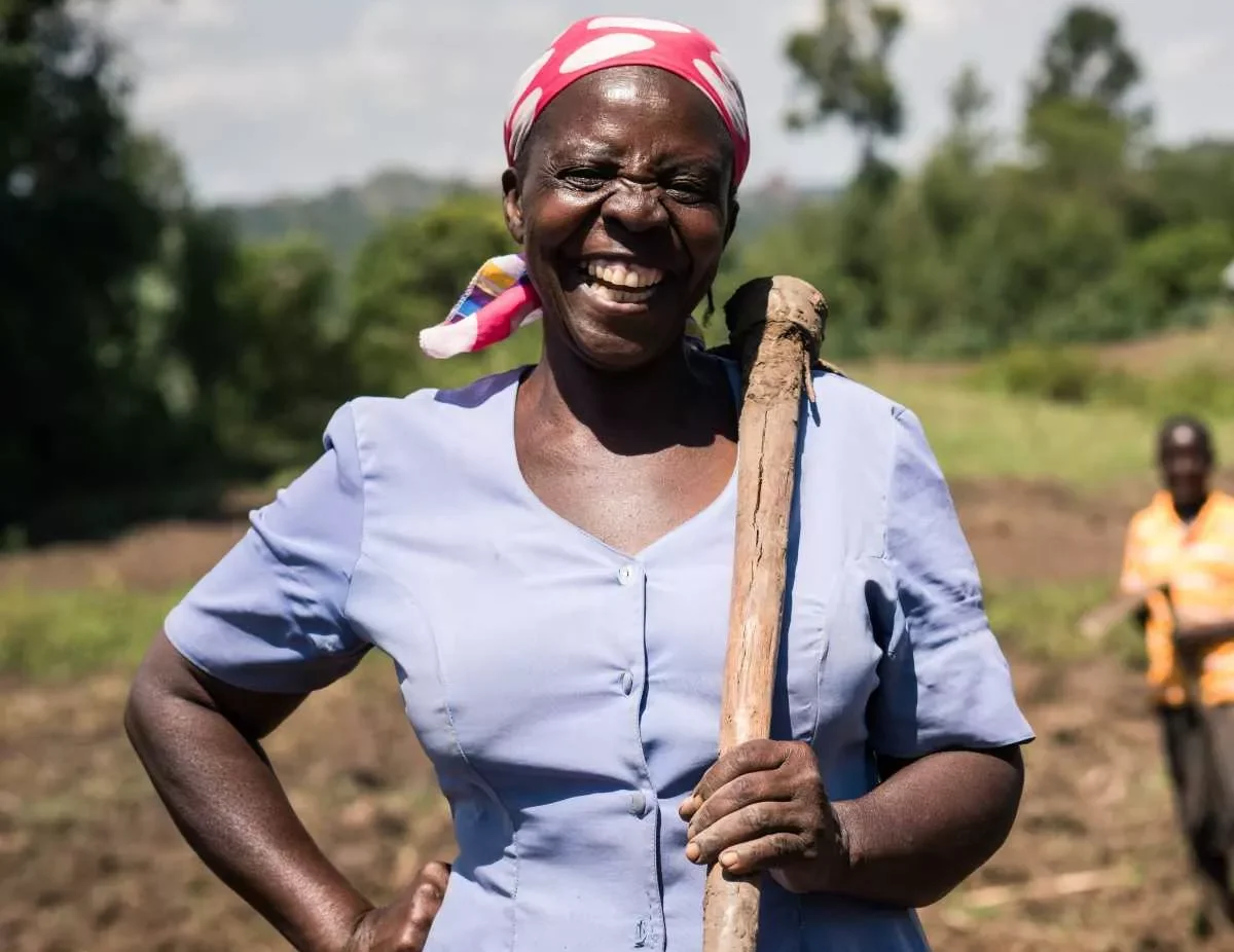 A female smallholder farmer from in Sub-Saharan Africa smiling into the camera