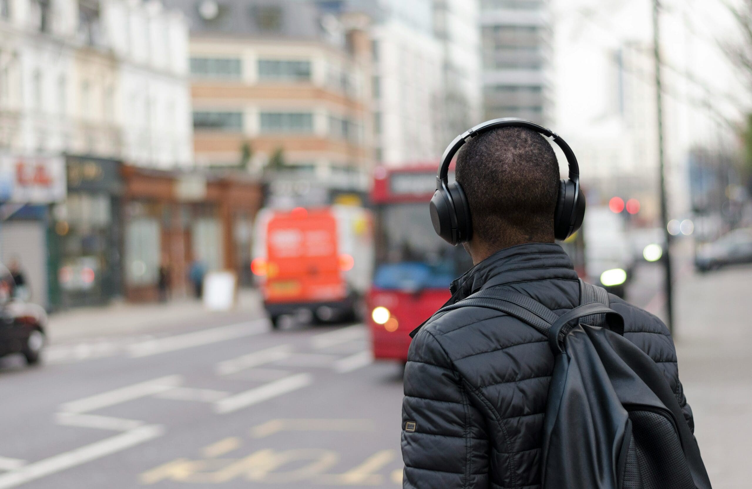 male listening to podcast on busy road
